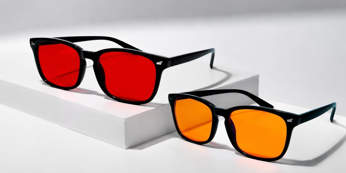 Gafas de luz azul Orenza con lente naranja y lente roja sobre fondo neutro